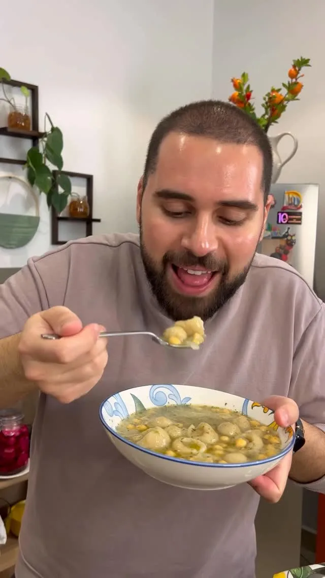Person eating soup from bowl.