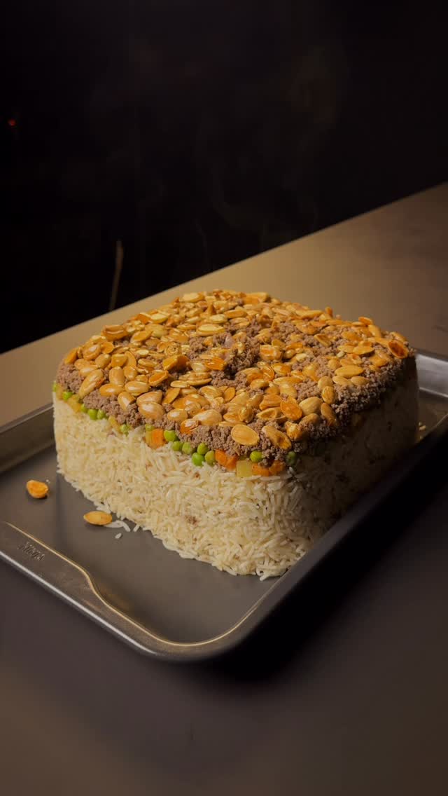أوزي باللحم والخضار مع رز بسمتي مقلوب في قالب، مزين باللوز المحمص